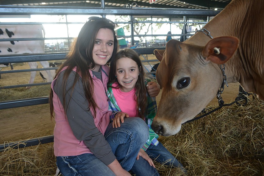 Myakka City 17-year-old, Karen Kotlarczyk, and East County 11-year-old Eva Gilmore are both members of Awesome Adventures 4-H of Myakka City. They visit with Jazz, a Jersey cow.