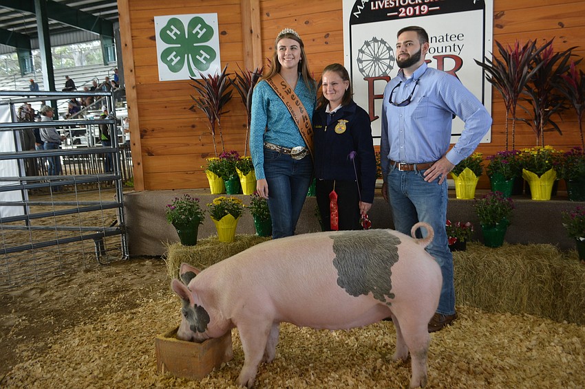 Manatee County Cattlemen Sweetheart Casey Wingate of Myakka City poses with Braden River senior Skyler Buechner, her pig, Noodle, and Eddie Mercurio, a Publix meat manager who bought the pig.