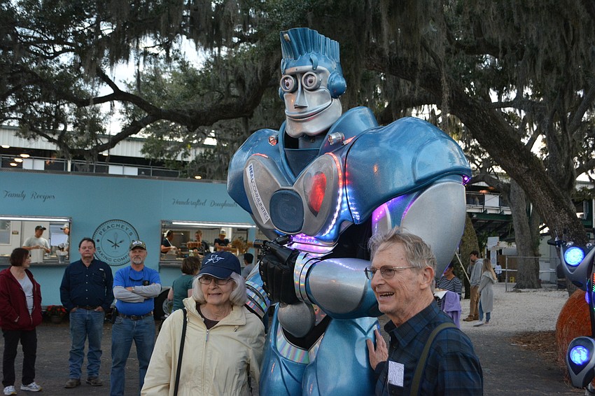 Palmetto's Virginia and Paul Carr share a laugh with Rocket-It the Robot, which roams the midway courtesy of Neal Communities.