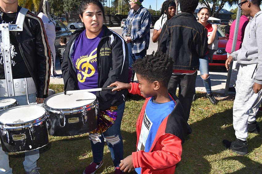 MJ Richardson uses Galilea Allende's drumstick, from Booker High School, to play around the drums.