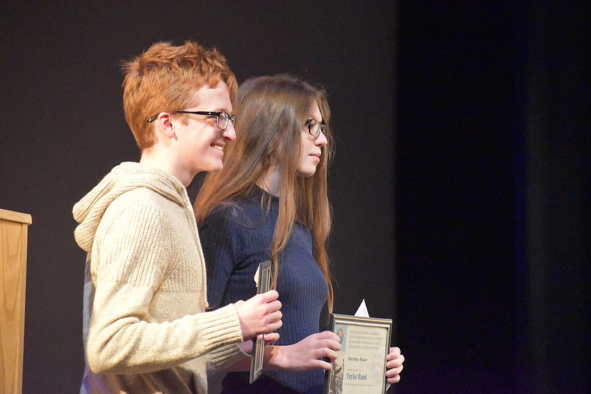 The other two winners of the essay contest, Mick Mazaeda and Taylor Rand, pose with their awards.