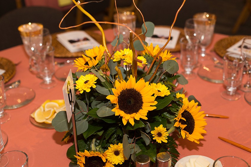 Sunflowers centered the tables with bright-coral tablecloths.