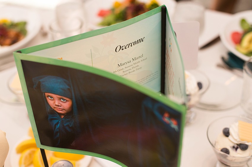 Print versions of artwork from the exhibit centered the tables.