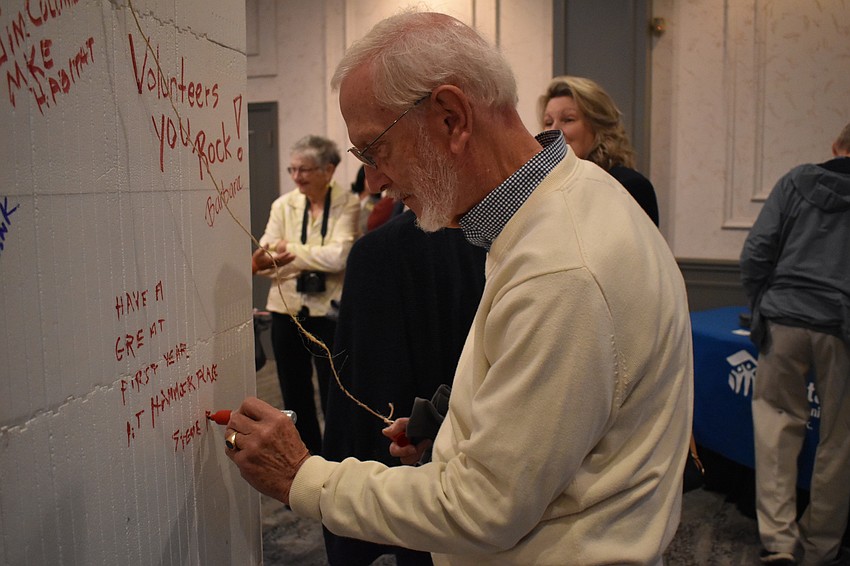 Steve Reid signs the board that will be built into a home for Habitat for Humanity.