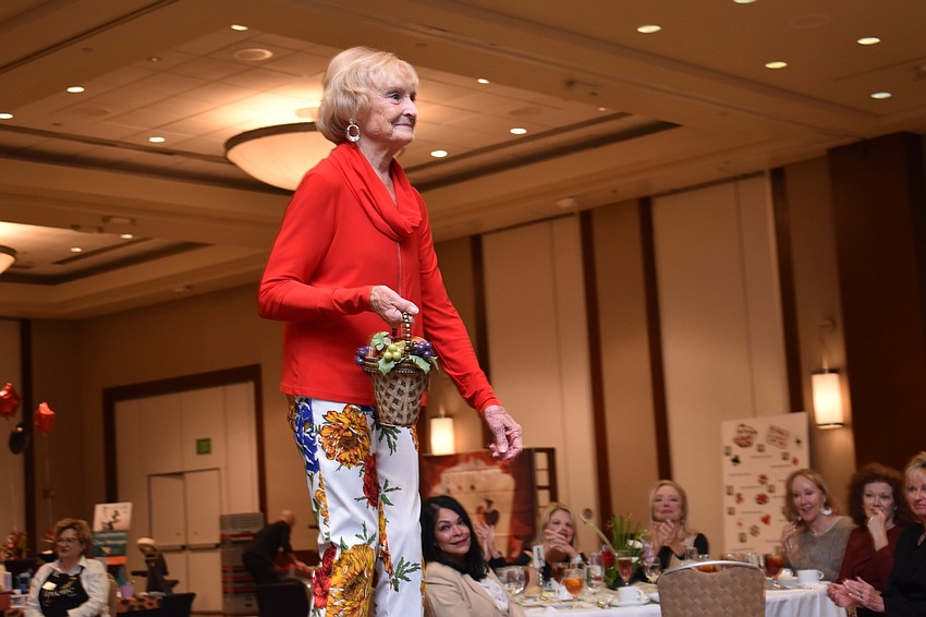 Carol O'Connor holds a floral themed bag on her way down the runway.