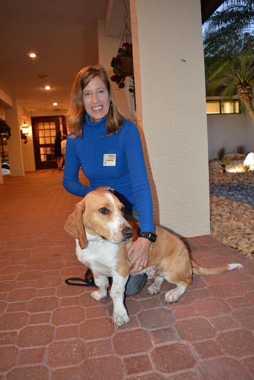 Humane Society of Sarasota volunteer Patty Rottenberg greets guests with Luke, a basset hound mix who is up for adoption.
