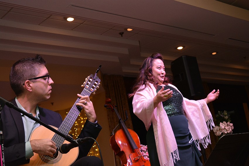 Guitarist Jon Godfrey accompanies  his wife, Jenny Kim-Godfrey, as she sings 