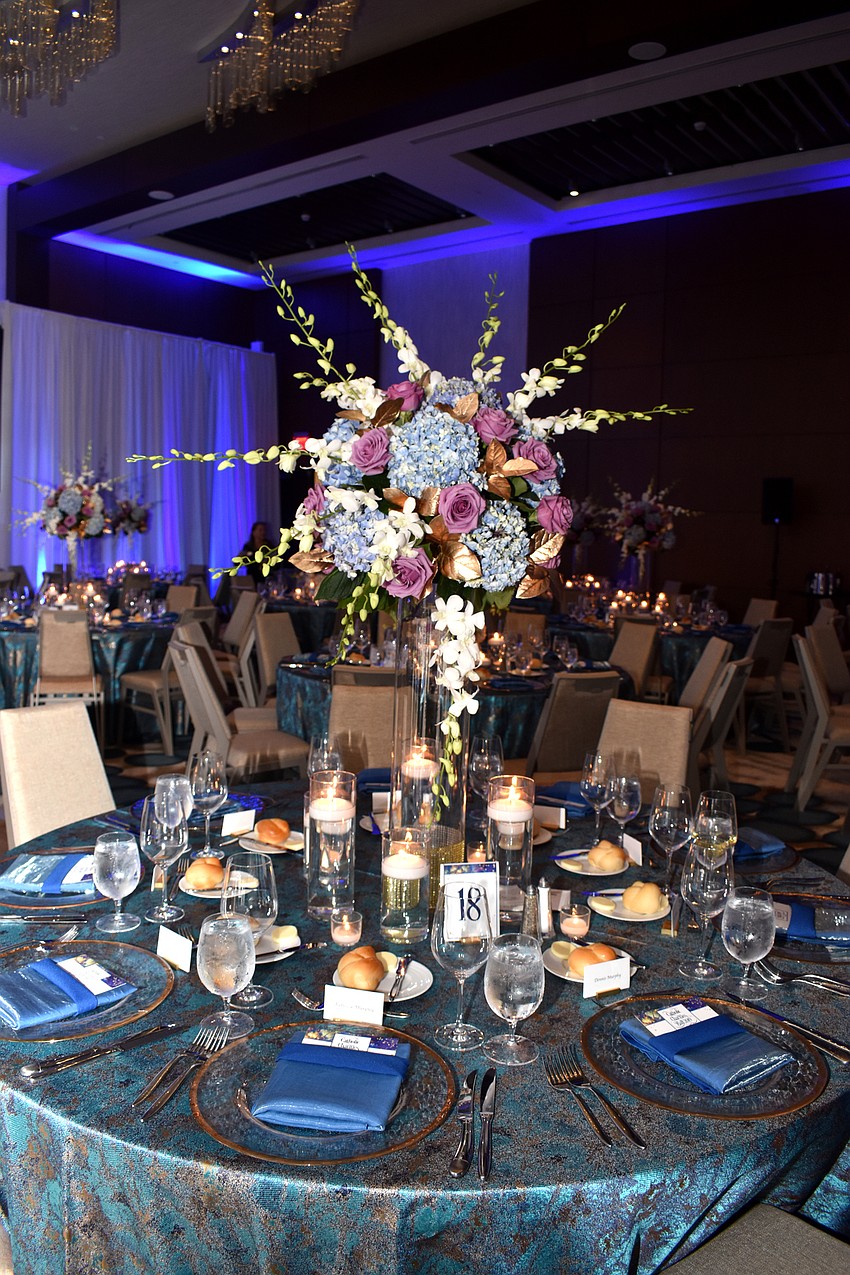 Blue hues and flowers adorn each dinner table.