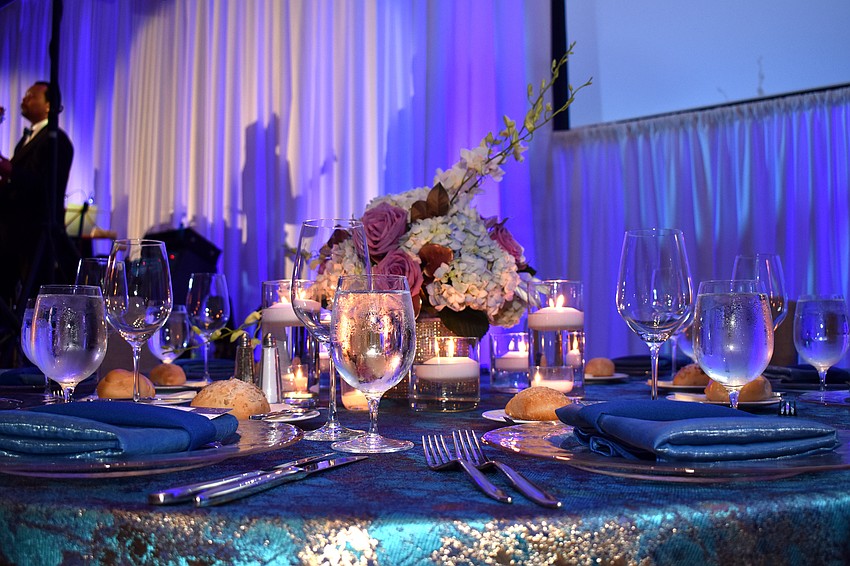Blue hues and flowers adorn each dinner table.