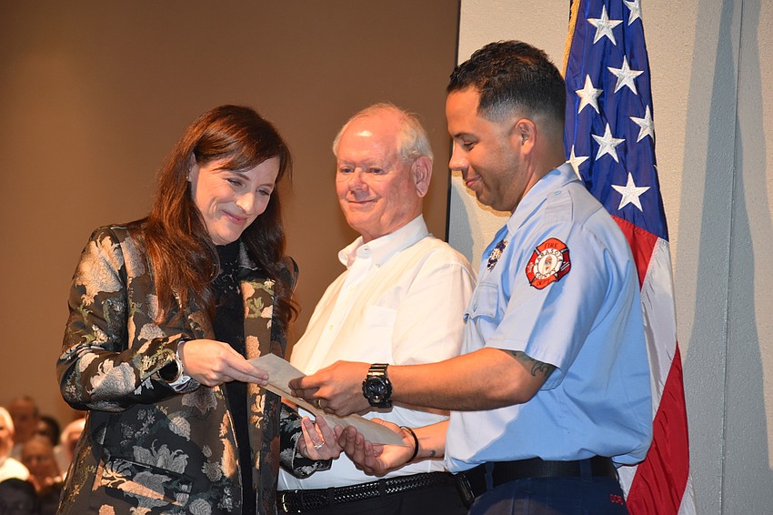 State Rep. Margaret Good, Larry Patton and Firefighter Jose Reyes read the proclamation given to Reyes for his service.