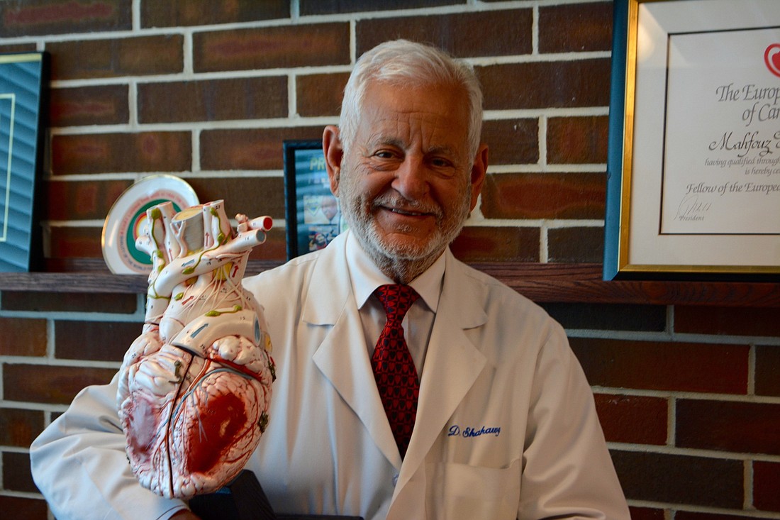 Dr. El Shahawy holding a large heart model.