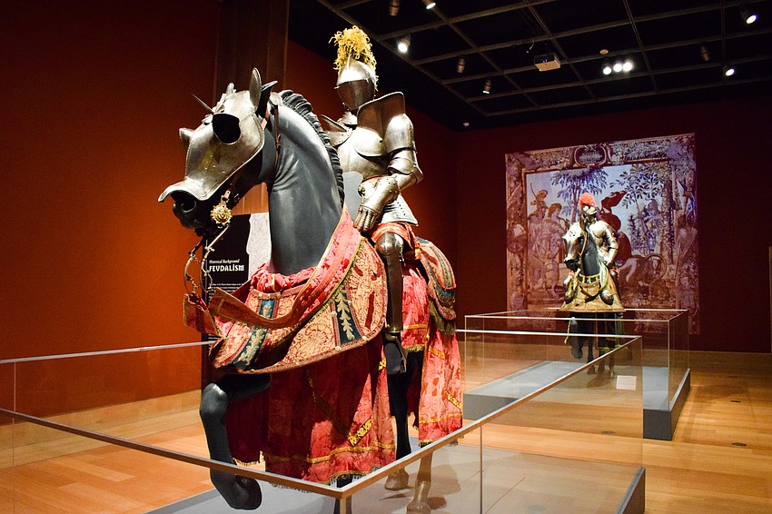 The exhibit features full suits of armor mounted on horses.