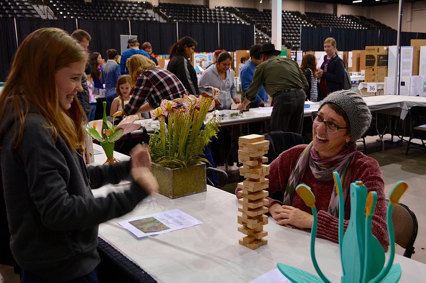 Fourth grade Addie Ross plays Jenga with Selby Gardens Senior Manager of School and Family Programs Tracy Calla.