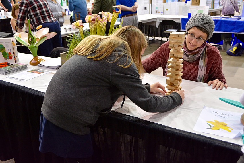 Tracy Calla plays Jenga with Addie Ross to teach her more about how the rainforest ecosystem is like Jenga.