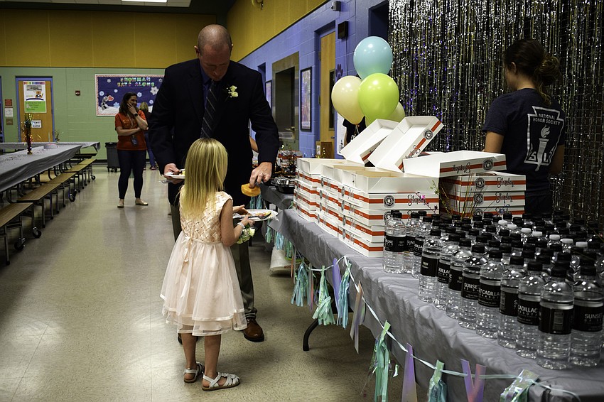 Ron Kennedy gets a donut for his daughter, kindergarten student Taylor, at the beginning of the dance. Early arrivers found themselves in a much shorter line.