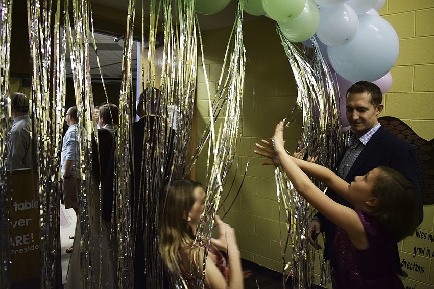 Chris Dillingham walks into the dance with his daughter, fourth-grader Julia, right, and her friend, Sophia, left.