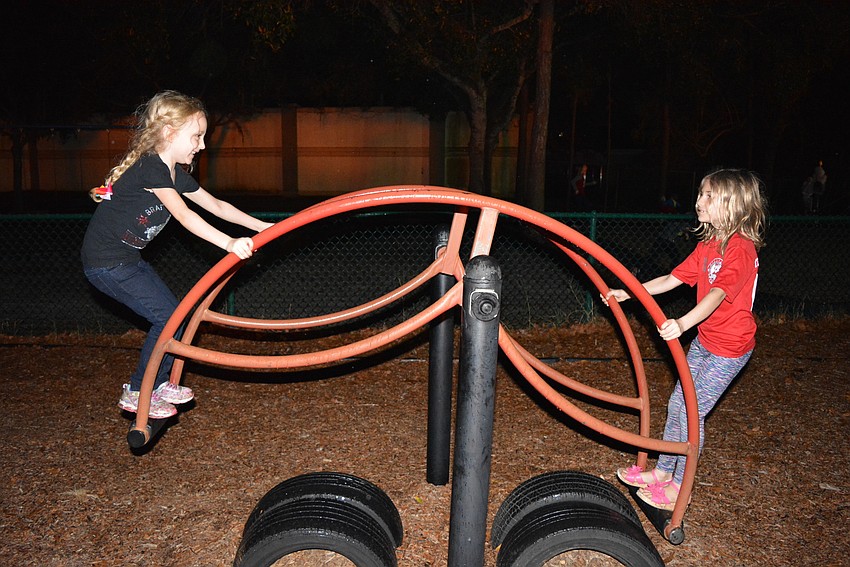 Six-year-old Ella Curran brings her friend Holly Tinley to the bonfire before they have a sleepover.