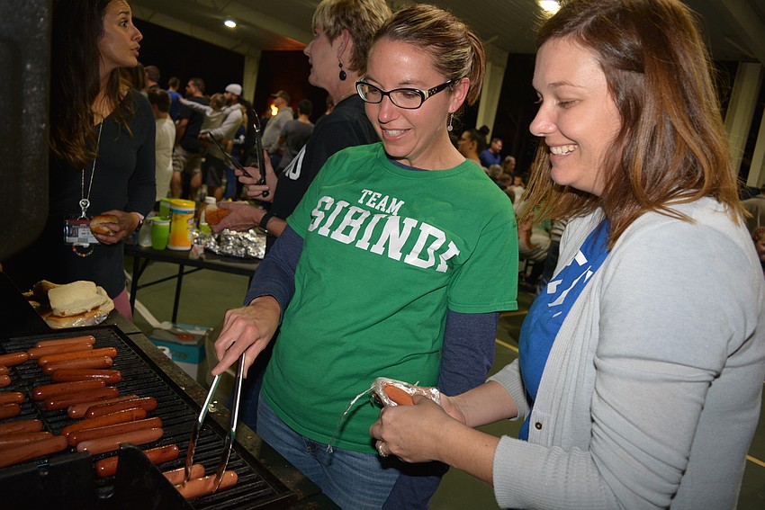 Volunteers Cortney Preston and Katie McCollum prepared about 200 hot dogs for guests by 7 p.m.