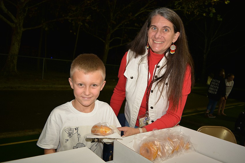 First-grader Wayne Comegno, pictured with second-grade teacher Mindy Walsh, wanted to help his mom, Iris, sell doughnuts.