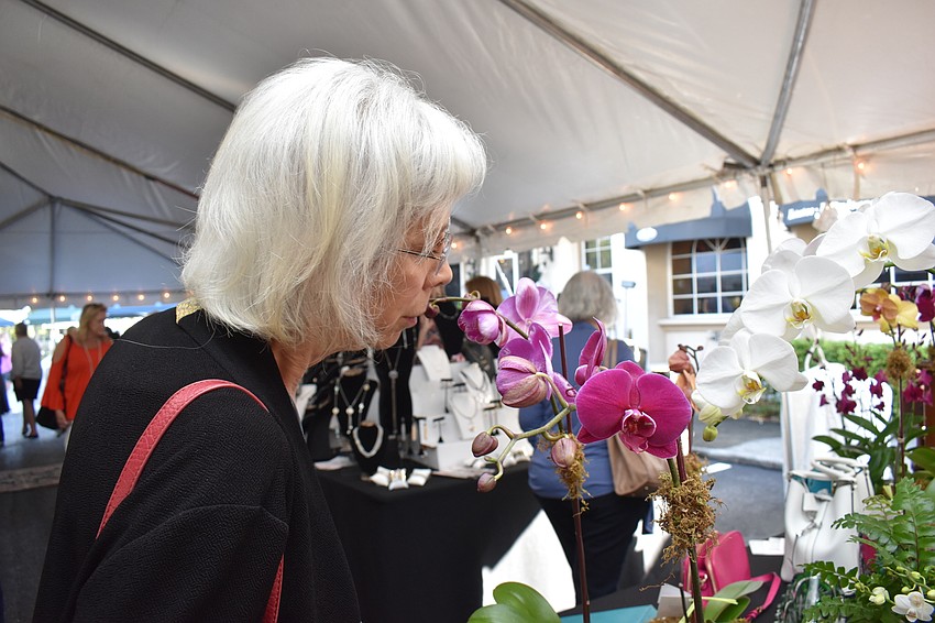 Pamela Tudor smells an orchid from Selby Gardens.