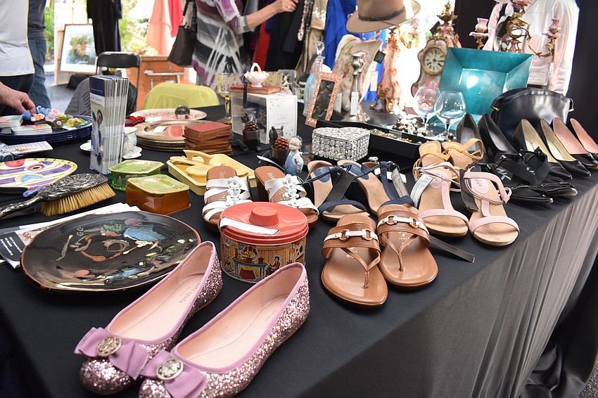There are tables of shoes, clothes and jewelry.