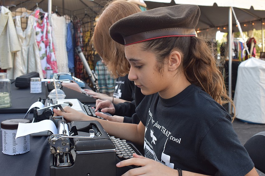 Celeste Flores from Booker Middle's Visual and Performing Arts school, types on her type writer for the Dragonfly Cafe Poets.
