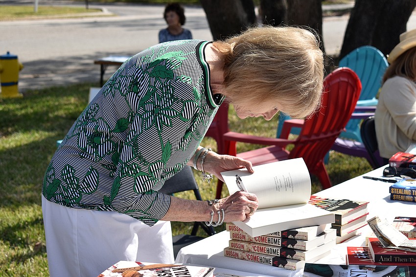 Pat Gussin signs a copy of her newest book, “Come Home.”