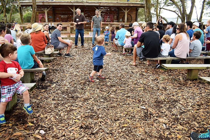 Mason Goldberg runs down the middle of the aisle while Rabbi Michael Shefrin and Brenner Glickman speak to the crowd.