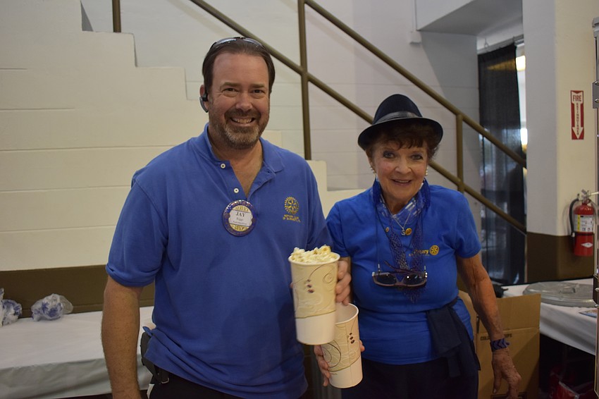 Rotary Club's Jay Riggs and Susie Lorbeck serve popcorn.