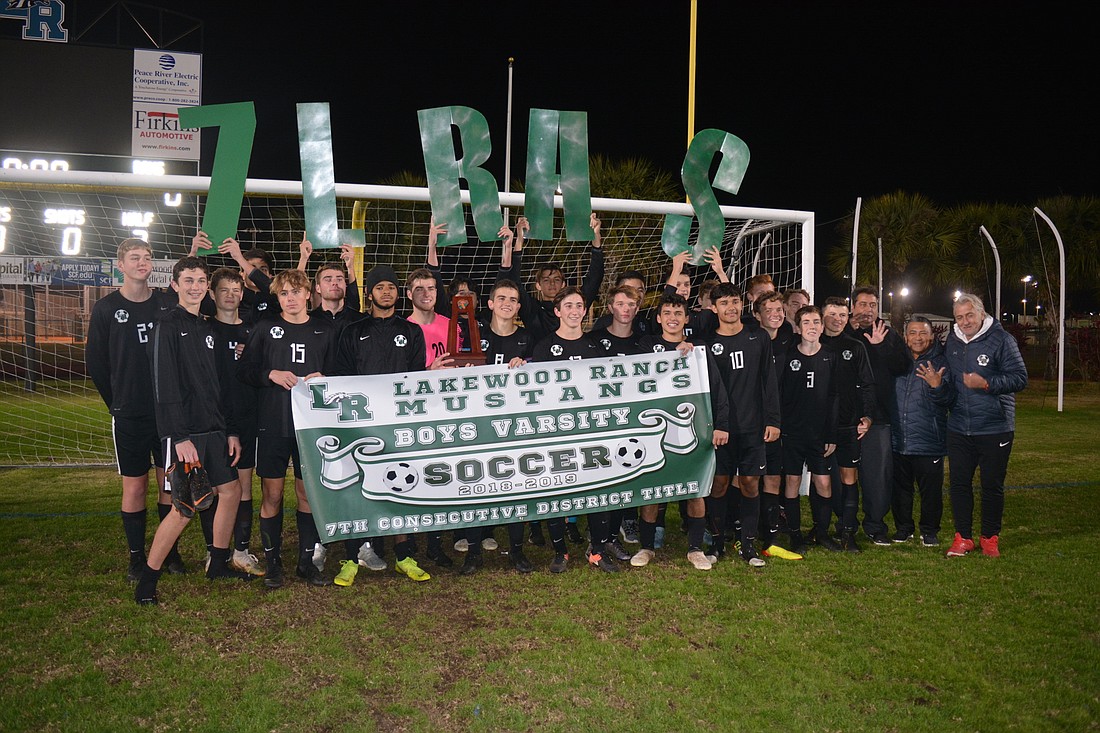 The Mustangs hold a banner celebrating their seventh-straight district title.