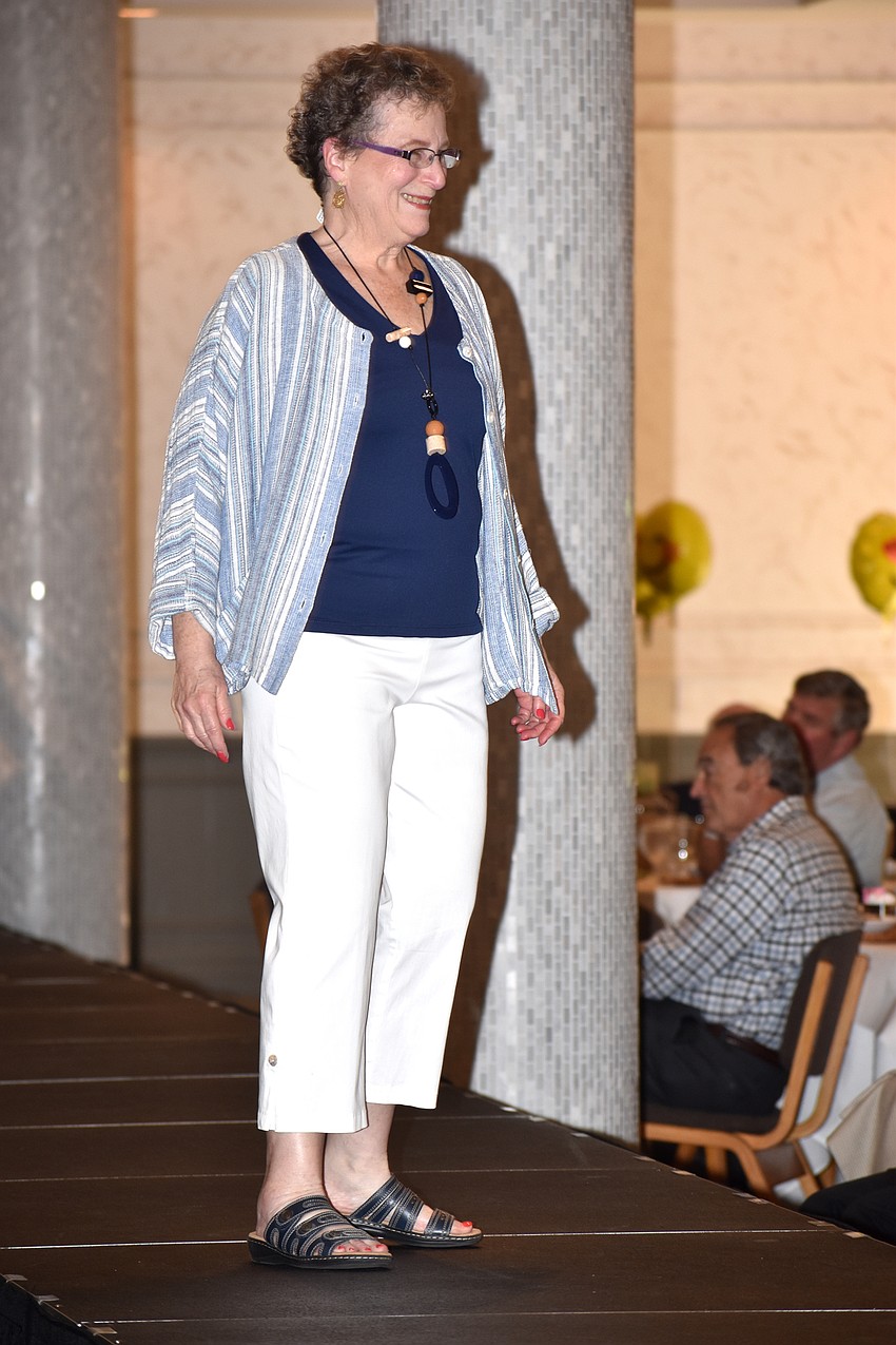 Teena Tessler smiles at friends as she walks the runway.