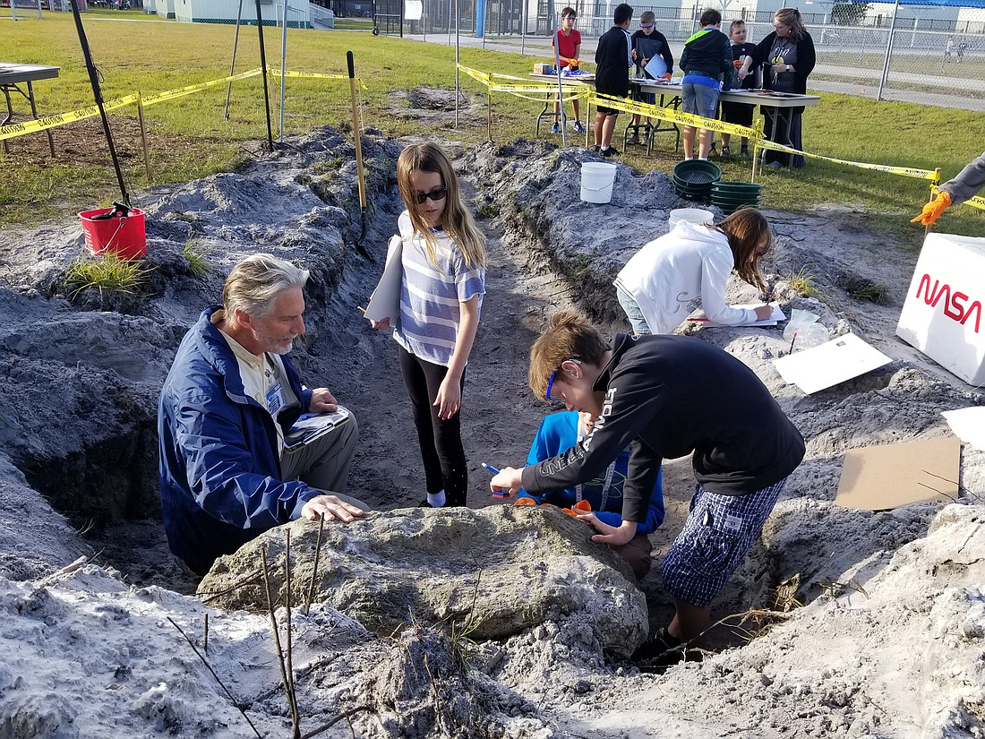 USF professor Dr. Dana Zeidler helps students as they take measurements of the meteorite.