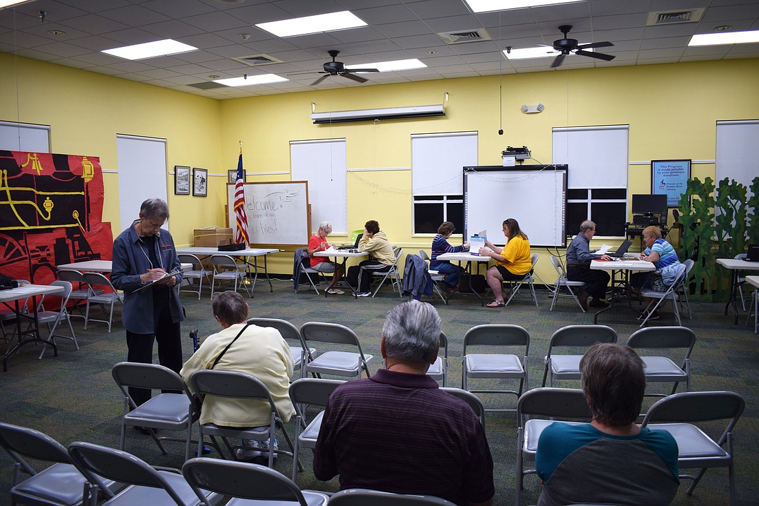 Clients wait to be called up by volunteers to have their taxes prepared at the Braden River Library on Wednesday, Feb. 6.