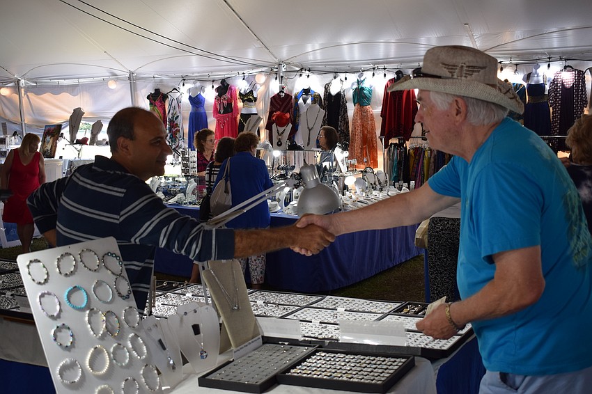 Joseph Khalipha, of the business Secrets of the Desert, shakes hands with patron Frank Callan, of Atlanta.