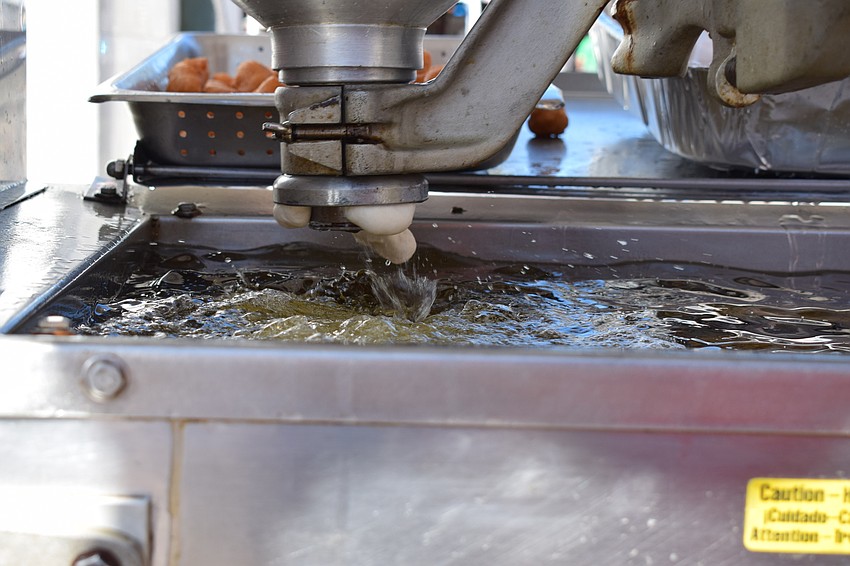 Alex Kiritsis cranks out the dough for loukumathes, a Greek fried dough.