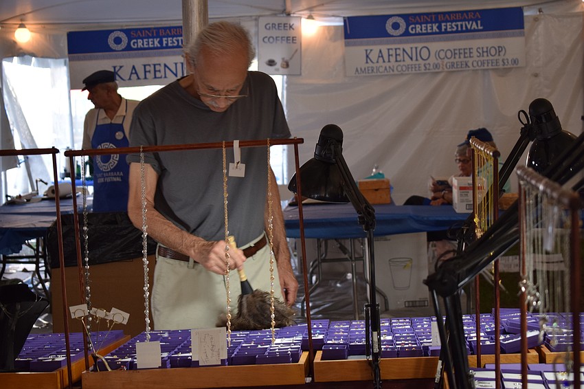 John Quartuccio dusts off his wares in the marketplace section of the festival.