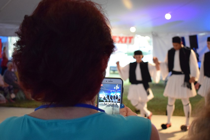 Guests record the action when Greek dancers begin their performance.