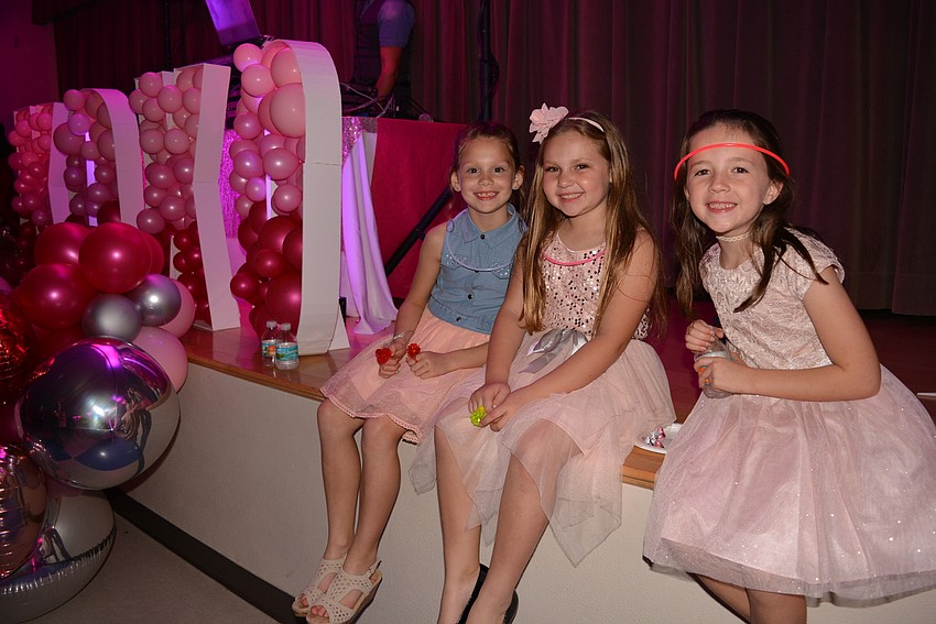 Julianne Medford, Carleigh Mueller and Brynn Defoor take a snack break on the stage and watch their friends keep dancing.