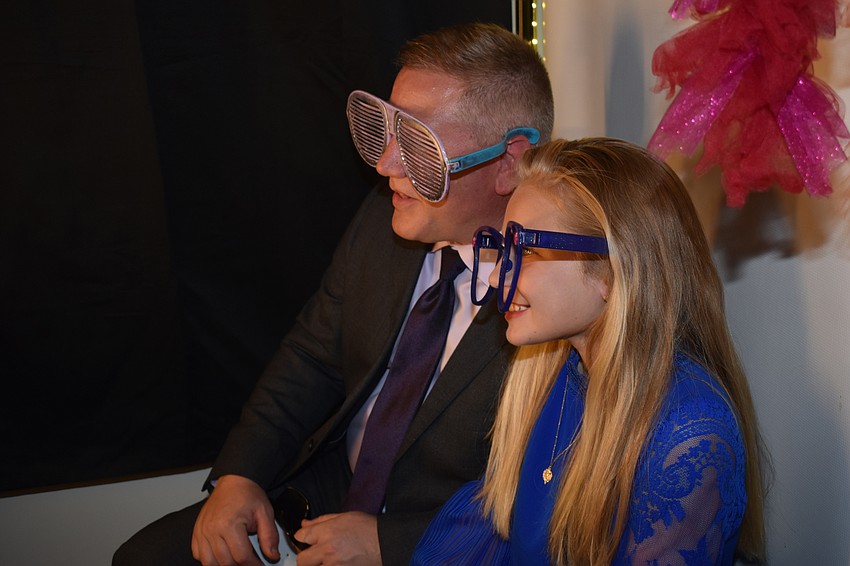 Barry Shuck and Olivia Shuck take a picture in the photo booth.