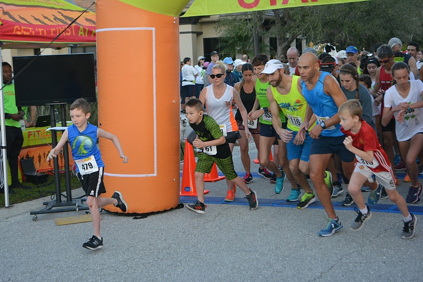 It was Sarasota 8-year-old David LaBonte who broke out first at the start of the 5K, but it was Sarasota's Matt Russell, at right in the blue shirt, who won.