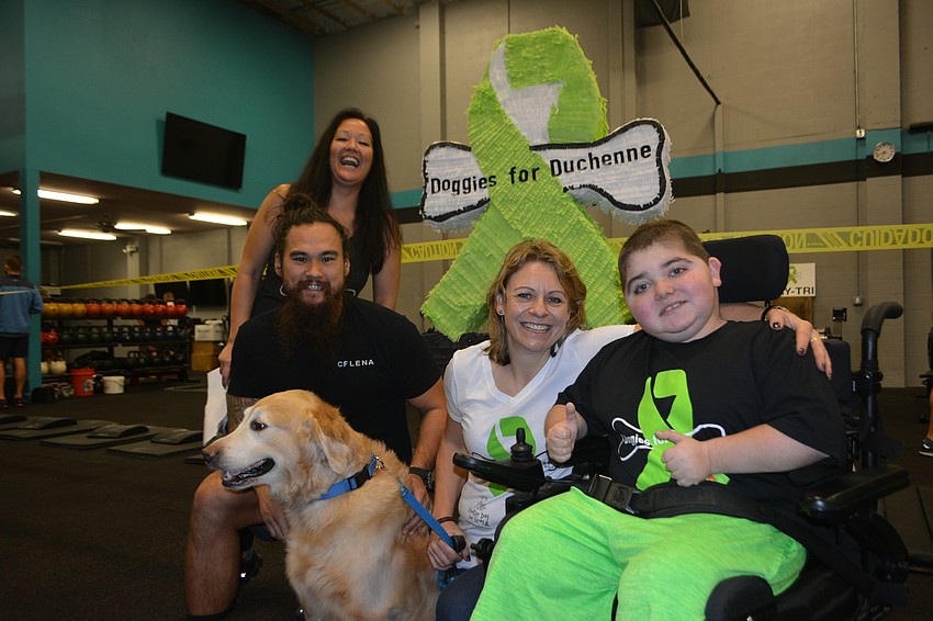Rebekah Boudrie (back), Josh Davis, service dog Hooch, Monaka Oberer and Grayson Tullio share a moment before the race.