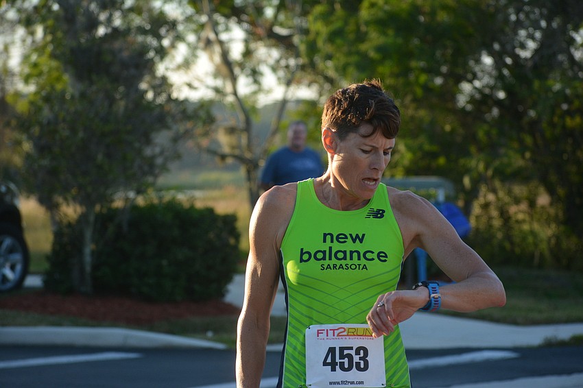 Nakomis' Heather Butcher checks her time of 19:03 after she was the first women's finisher in the 5K.