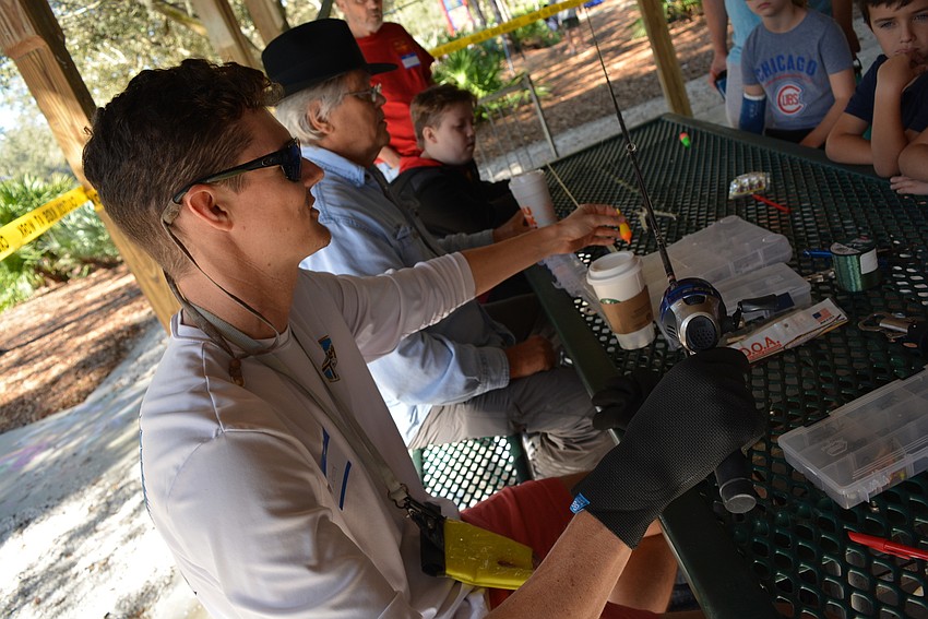 Lakewood Ranch Angler  Derek Sledjeski teaches children how to assemble their new fishing poles and about using a bobber.