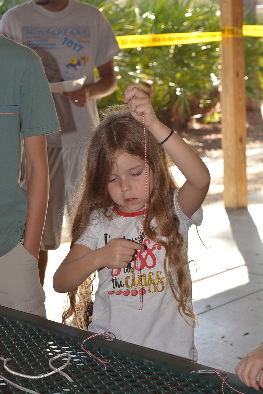 River Langford, 6, learns to tie a knot.