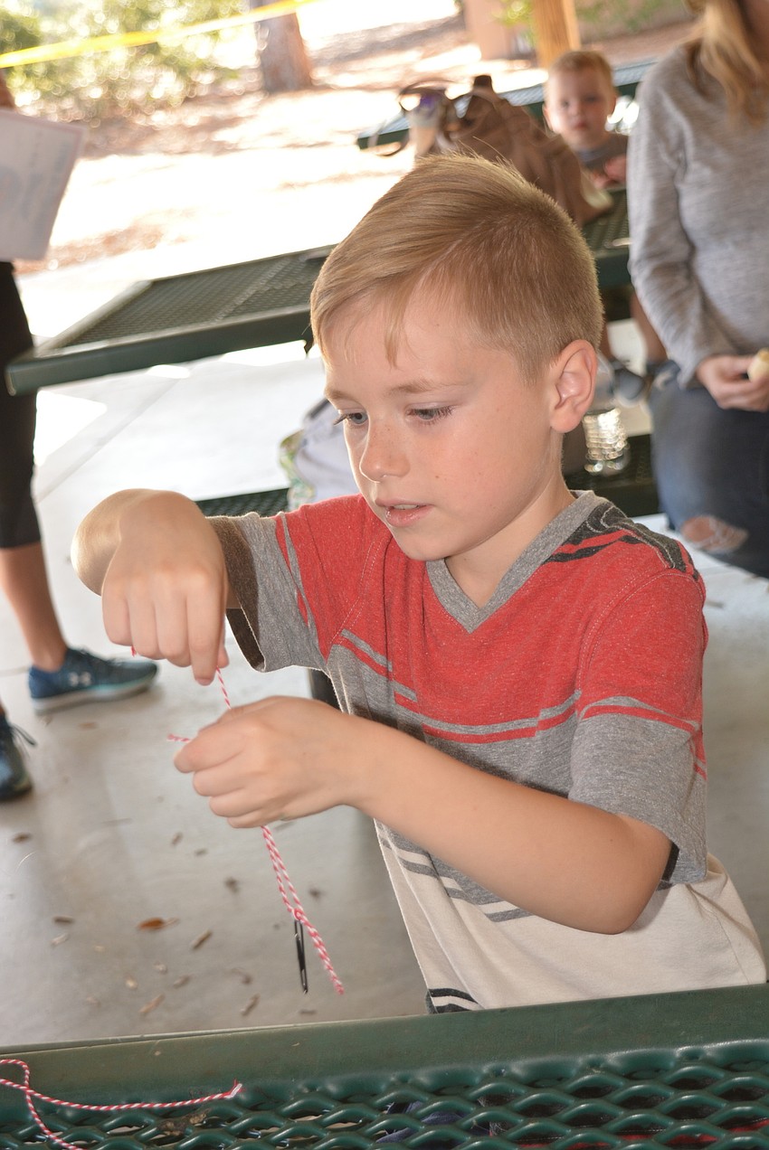 Summerfield's Dryden Langford, 7, practices tying a knot for a hook.