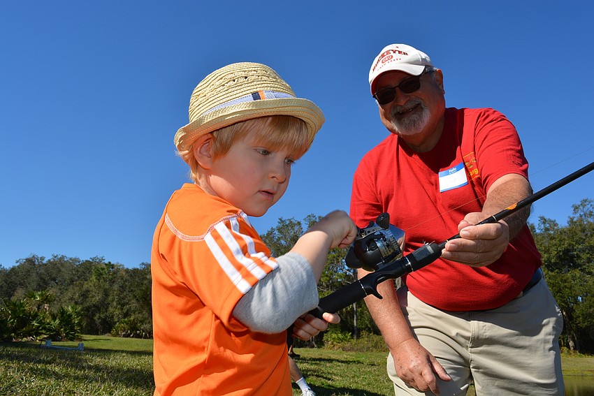 Five-year-old Mark Eubanks gets some casting pointers from angler Chip Morrill.