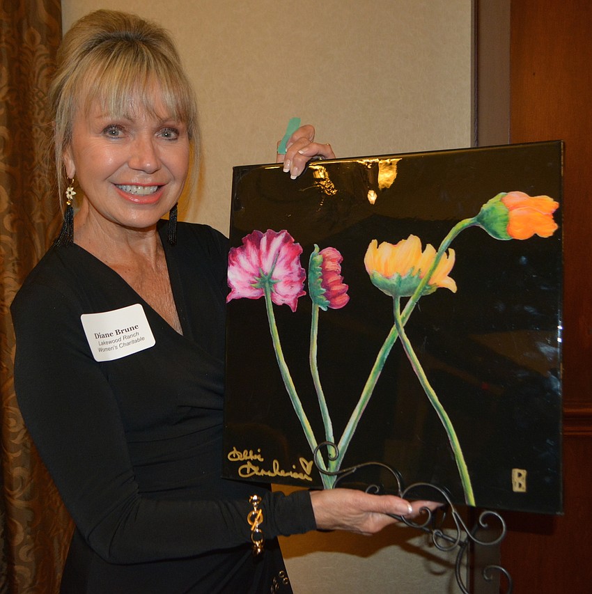 Diane Brune, the Lakewood Ranch Community Fund's 2018 John Clarke Humanitarian Award winner, shows off the artwork she won in a raffle.
