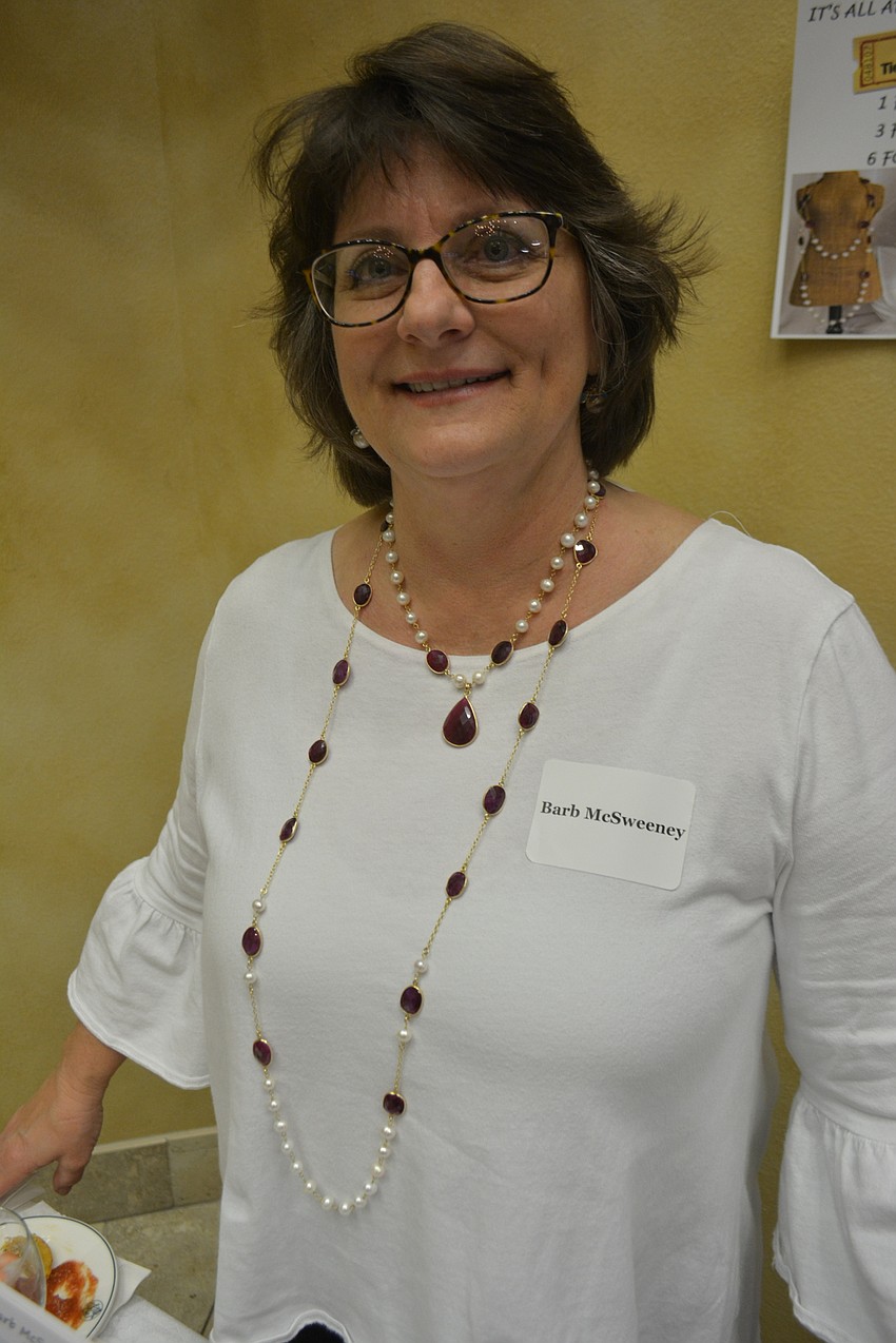 Barb McSweeney shows off necklaces she donated to be raffled off during the event. The longer necklace was valued at $395 while the shorter one was $265 and included a pair of earrings valued at $195.