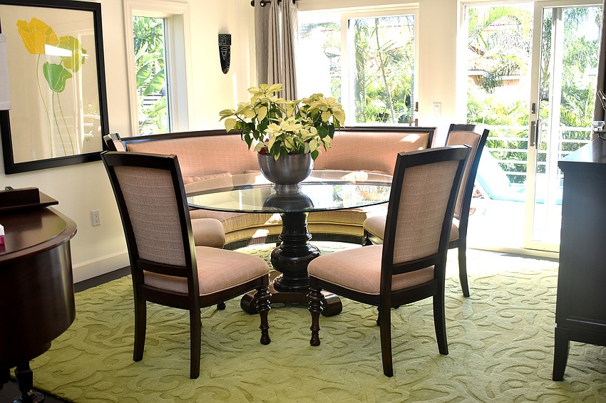 A dining room sits off the kitchen with views of the pool.