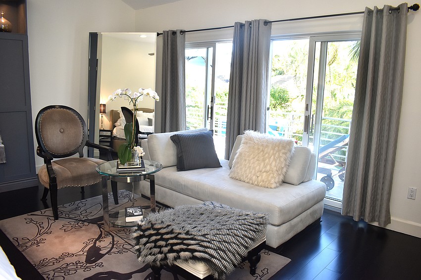 A chaise lounge and other seating with a view overlooking the pool.